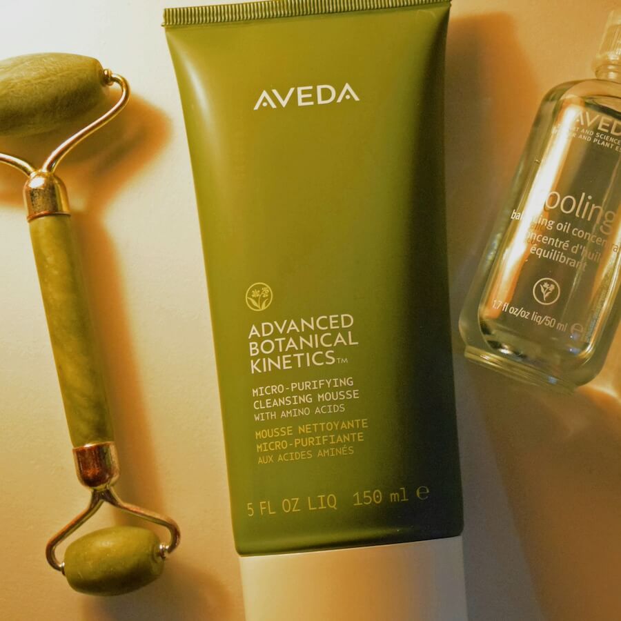 A relaxing wellness flat-lay featuring Aveda Botanical Kinetics skincare and face roller